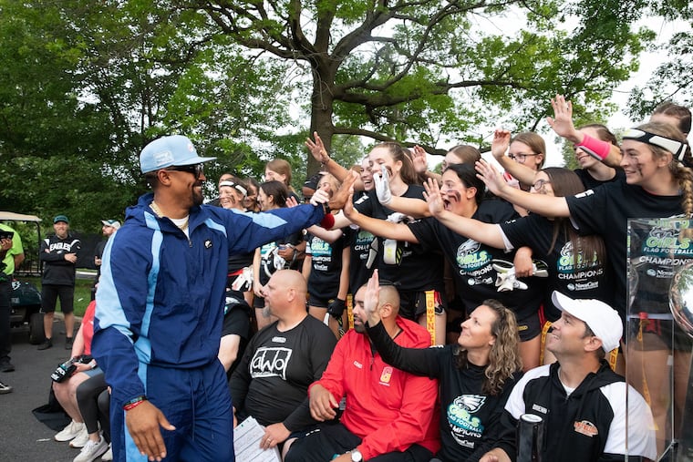 Jalen Hurts celebrates with the Gwynedd Mercy Academy girls’ flag football team on Sunday.