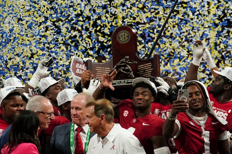Alabama quarterback Jalen Milroe (center) and the Crimson Tide hoist the championship trophy after the Southeastern Conference championship against Georgia on Saturday.