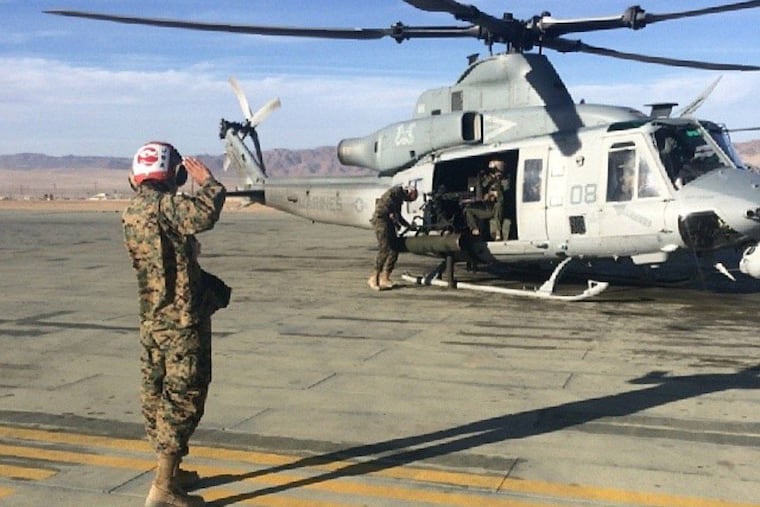 As the quality assurance/safety officer in charge of an arming evolution on a UH-1Y helicopter, the author directs a team of Marines through a sequence of armaments via hand signals during an integrated training exercise at Marine Corps Air Ground Combat Center, 29 Palms, Calif., in 2014.