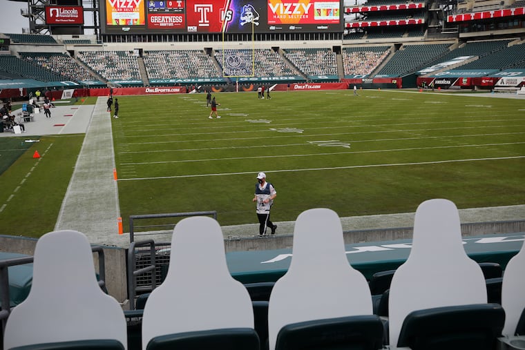 An official walks across the field during a delay before the Temple-East Carolina football game at Lincoln Financial Field in South Philadelphia on Saturday, Nov. 21, 2020.