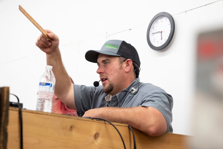 Professional auctioneer Brian Oberholtzer calls an auction at H&R Auctions in New Holland, Pa., on June 14, 2021. In May, after several past top-10 finishes, Oberholtzer, 36, won the Pennsylvania Auctioneers Association’s statewide bid-calling competition in Harrisburg.