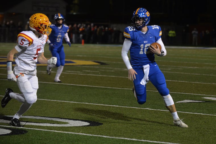 Will Howard of Downingtown West scrambles as Haverford's Justin Burgess approaches in Friday night's District 1 Class 6A semifinal. Downingtown West won the game, 49-42.