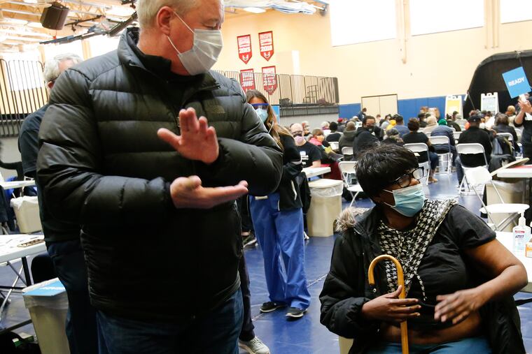 Mayor Jim Kenney claps for Barbara Pankey after Pankey received the COVID-19 vaccination at the School of the Future in West Philadelphia. Penn Medicine and Mercy Catholic Medical Center came together with a coalition of religious and community leaders from West Philadelphia to hold a mass COVID-19 vaccination clinic for 1,500 members of the local community.