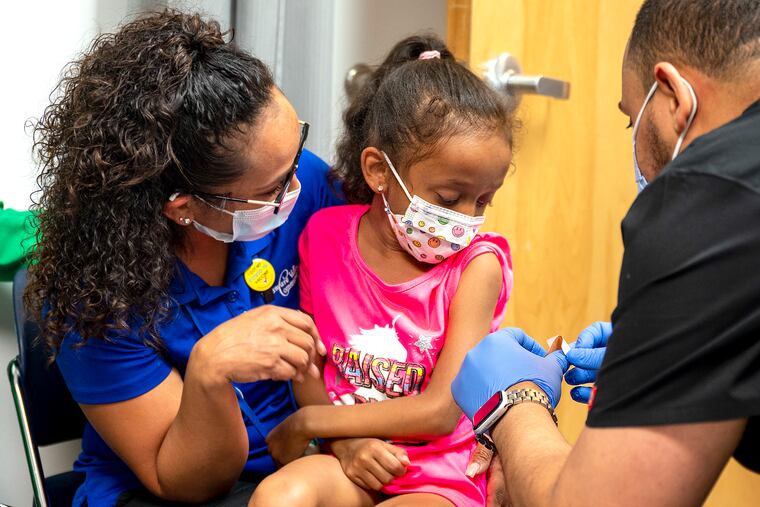 Celines Mendez holds her daughter, Isabella Aguilar, 5, as she receives her COVID-19 vaccination at the María de los Santos Women's Health Center on June 30.