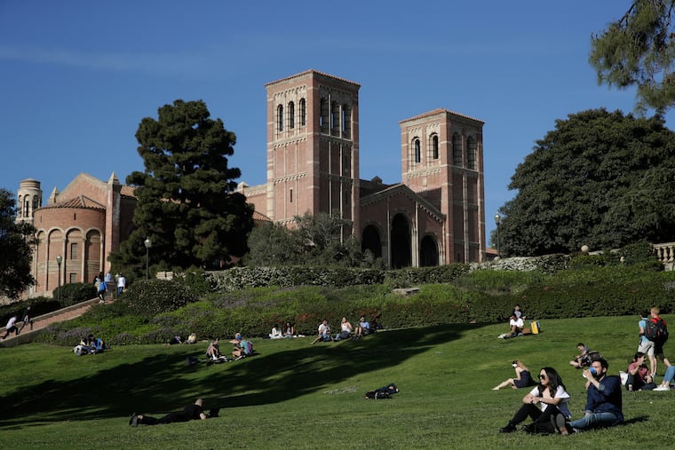 FILE - Students sit on the lawn near Royce Hall at UCLA in the Westwood section of Los Angeles on April 25, 2019.