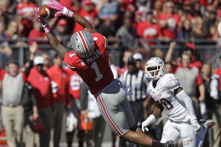 Ohio State receiver Braxton Miller, left, catches a pass in front of Maryland defensive back Anthony Nixon during the second quarter of an NCAA college football game Saturday, Oct. 10, 2015, in Columbus, Ohio.