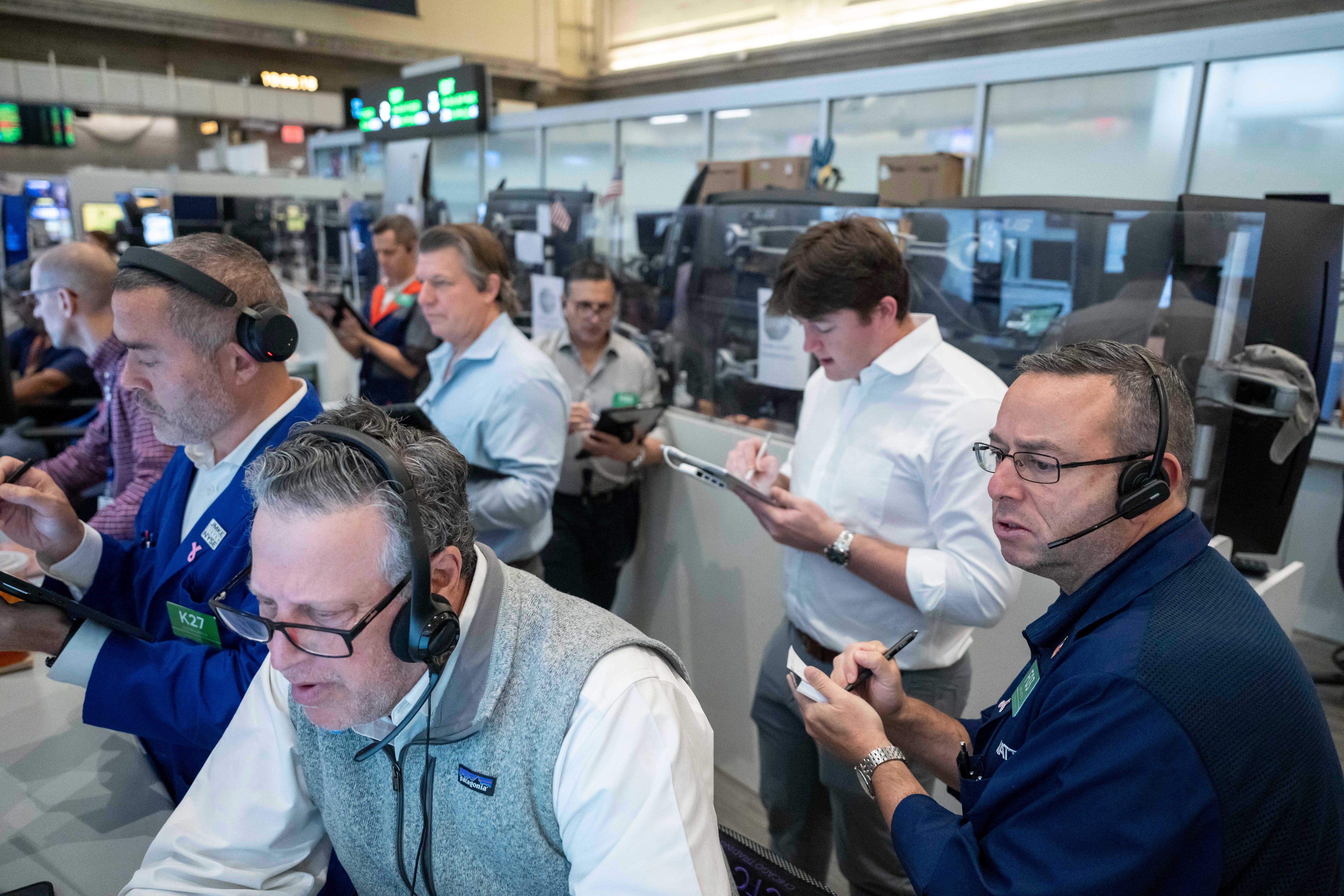 US stocks hover near their latest record in mixed trading on Wall Street