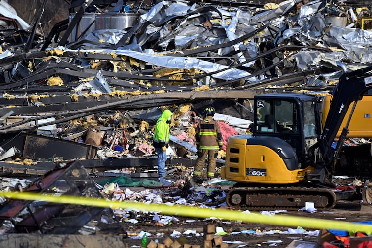 Emergency response workers dig through the rubble of the Mayfield Consumer Products candle factory in Mayfield, Ky., on Saturday.