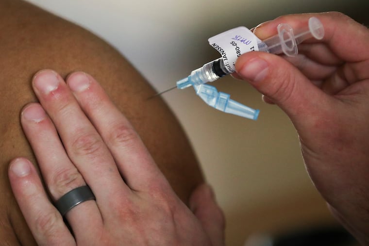 A resident receives a dose of the Johnson & Johnson COVID-19 vaccine at the Mickle Towers housing complex in Camden.