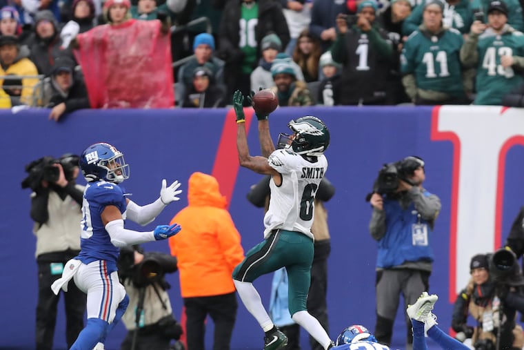 Eagles wide receiver DeVonta Smith catches the football for a second-quarter touchdown past New York Giants cornerback Darnay Holmes (on ground) and safety Julian Love at MetLife Stadium in East Rutherford, New Jersey on Sunday, December 11, 2022.
