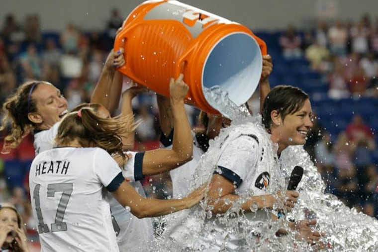 United States' Abby Wambach (right) is showered by teammates after an international friendly soccer match against South Korea at Red Bull Arena, Thursday, June 20, 2013, in Harrison, N.J. The U.S. won 5-0. Wambach is now the greatest goal scorer in international soccer. She scored four goals in the first half to break Mia Hamm's record. (Julio Cortez/AP)