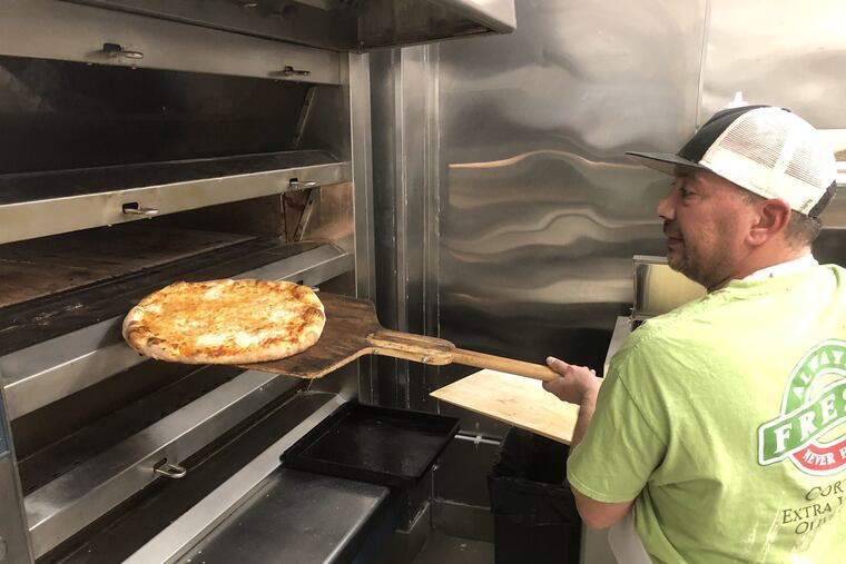 Danny DiGiampietro loads a pizza into the oven at Angelo's Pizza in South Philadelphia.