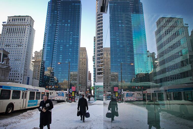 Pedestrians make their way through center city Philadelphia along 15th St. and JFK early Wednesday, January 22, 2014. Heavy snowfall from the day before, cold temperatures and blowing wind make getting around difficult. ( ALEJANDRO A. ALVAREZ / STAFF PHOTOGRAPHER )