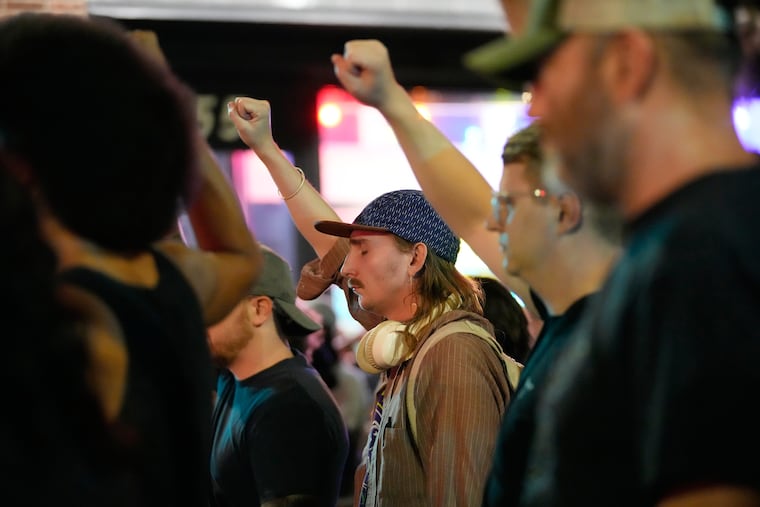 Attendees gesture during a candlelight vigil after a Madison police officer shot and killed a man Wednesday in Wisconsin's capital city.