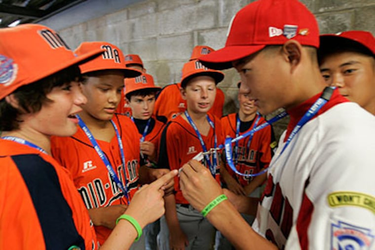 Natsuki Mizumachi of Japan meets Patrick Marinaccio and other players from Toms River team representing the Mid Atlantic team. (David Swanson / Staff Photographer)