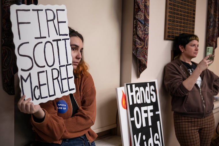 Alexa McDonald (left) and Bonnie Koehler display signs during a council meeting as members of the community speak out against the actions of Police Chief Scott McElree on Wednesday, March 4, 2026 in Quakertown.