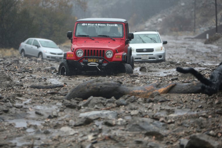 A mudslide trapped several vehicles along Valley of the Falls Drive in Forest Falls in San Bernardino County, Calif., on Thursday, Nov. 29, 2018. Forecasters say the weather system that has been raining all day on Southern California has developed instability and may produce thunderstorms. Mud and rock slides have also closed two mountain highways northeast of Los Angeles. (Stan Lim/The Orange County Register via AP)