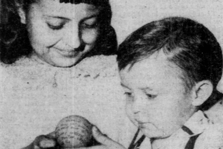 Marie Ann Mazur, 11, shows her brother, Joey, 3, the ball she found after it was thrown over the wall of Eastern State Penitentiary by an inmate.