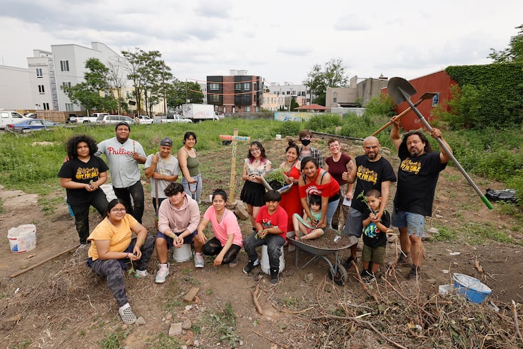 Folks take a break, from farming on a vacant lot, for a group photo next to the César Andreu Iglesias Community Garden in the West Kensington section of Philadelphia, on May 22, 2021.