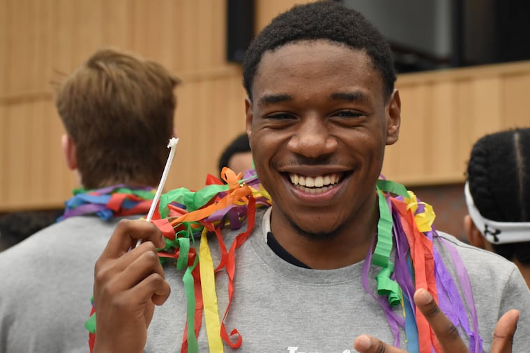 Matthue Cotton celebrates with a piece of the net after Yale won the Ivy League men's basketball tournament.
