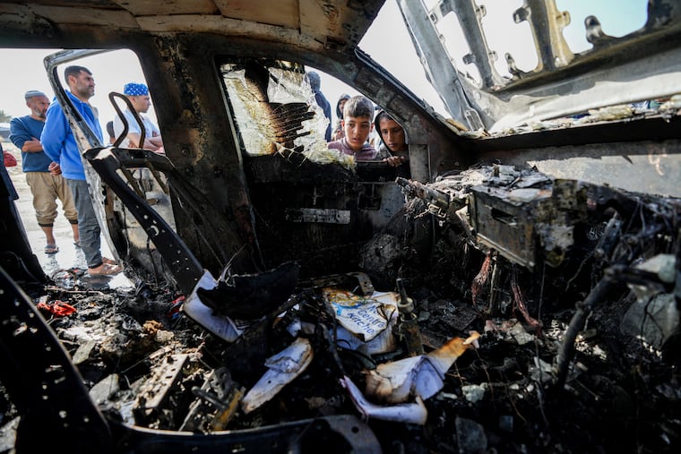 People inspect the site where World Central Kitchen workers were killed in Deir al-Balah, Gaza Strip, on Tuesday, April 2, 2024.