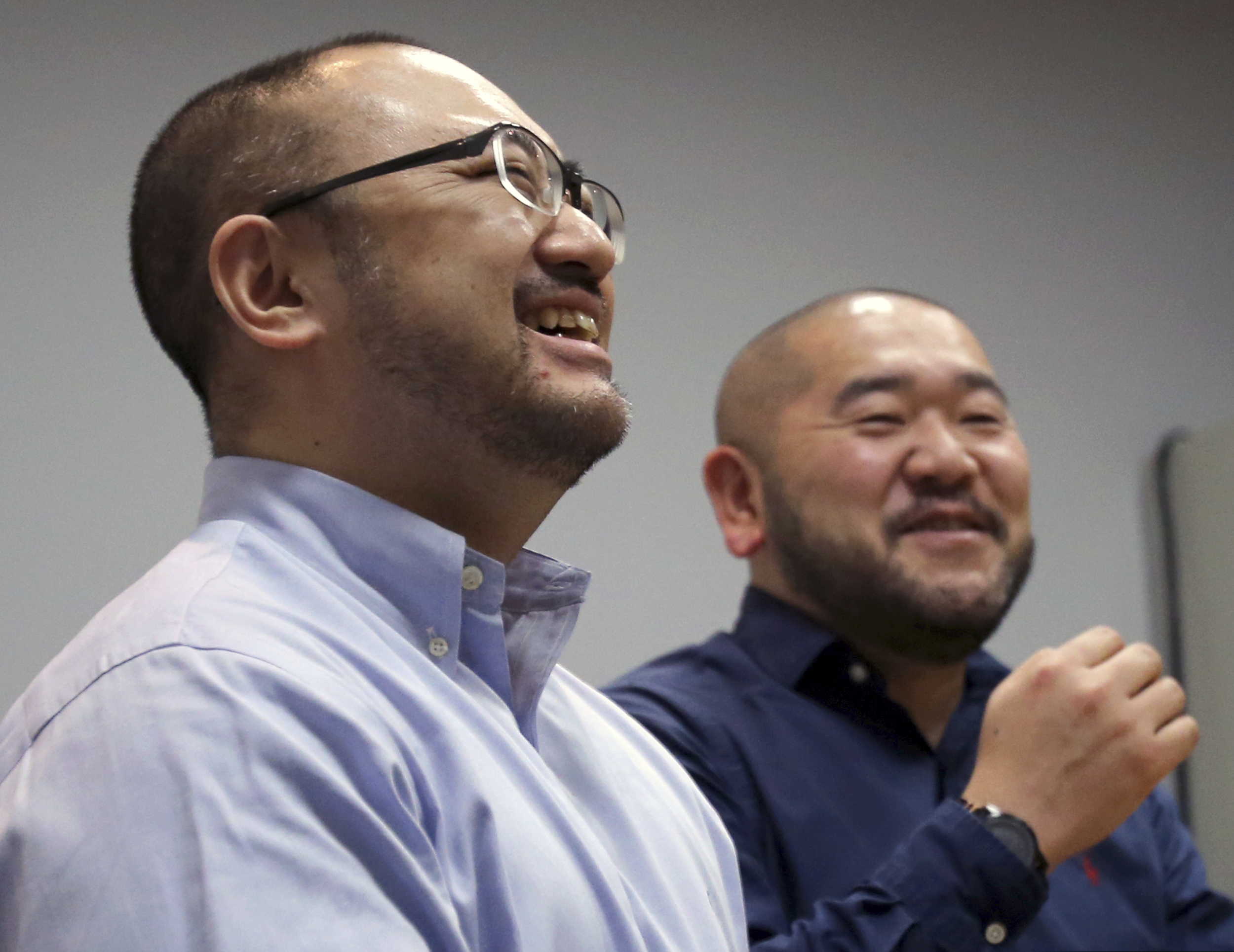 In this Jan. 28, 2019, photo, Kenji Aiba (left) and his partner, Ken Kozumi, laugh during an interview with the Associated Press in Tokyo. Kozumi and Aiba have held onto a marriage certificate they signed at their wedding party in 2013, anticipating that Japan would emulate other advanced nations and legalize same-sex unions. That day has yet to come, and legally they are just friends even though they've lived as a married couple for more than five years. On Thursday, Feb. 14, 2019, Valentine’s Day, the couple is joining a dozen other same-sex couples in Japan’s first lawsuits challenging the constitutionality of the country’s rejection of same-sex marriage.