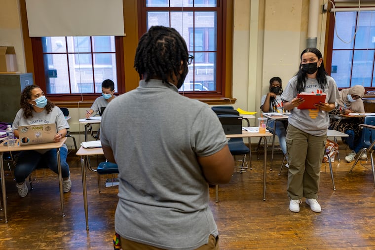 Philadelphia School District program supervisor David Chaney Jr. listens to Lexcie Velez make her elevator pitch in a Philadelphia School District summer program for aspiring entrepreneurs.