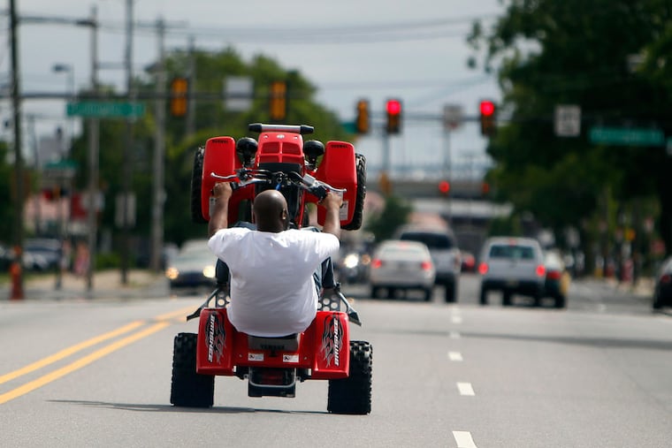 ATV rider, Mook, who didn't want to give his real name, wheelies down Lehigh Avenue on a recent Sunday ride. Mook is a member of Philly Hang Gang. Operating an ATV or dirt bike is illegal in Philadelphia.