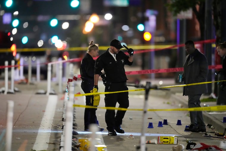 Denver Police Department investigators work the scene of a mass shooting along Market Street between 20th and 21st Streets during a celebration after the Denver Nuggets won the team's first NBA title.