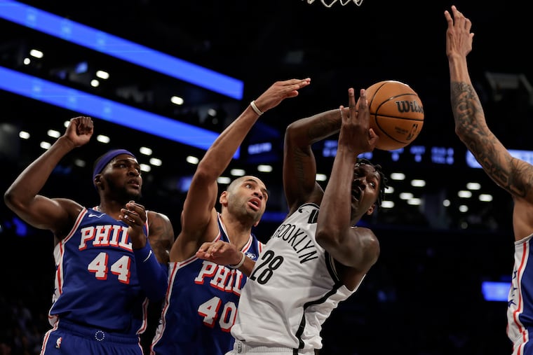 Brooklyn Nets forward Dorian Finney-Smith passes in front of 76ers forward Nicolas Batum (40) during Tuesday night's game.