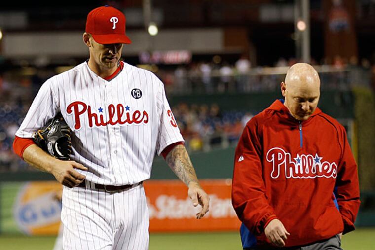 A.J. Burnett walks to the Phillies dugout with head trainer Scott Sheridan. (Yong Kim/Staff Photographer)