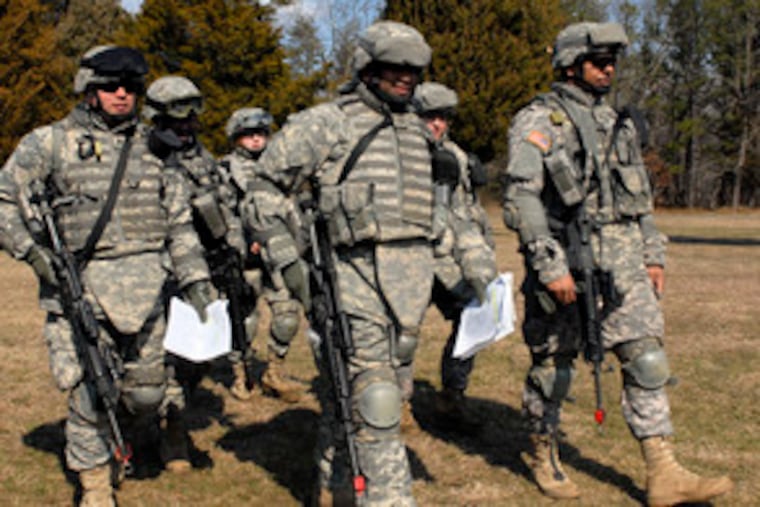 After a five-mile walk in the woods, Army Reservists head back to their base at Fort Dix. Philadelphia Police Officer William Phillips (far right) said his work in the city has prepared him well for teaching community policing in Iraq.
