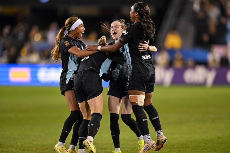 Rose Lavelle (center) celebrates with teammates after scoring the winning goal.