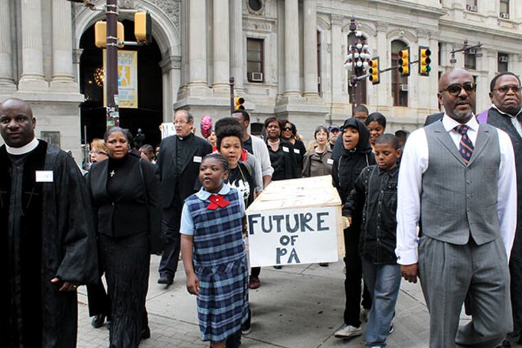 Members of Philadelphians Organize to Witness, Empower and Rebuild (POWER) and local school children march a fake casket down Broad Street during a mock funeral held for the Philadelphia School District as part of a demonstration at City Hall in Philadelphia on Friday, May 9, 2014. ( COURTNEY MARABELLA / Staff Photographer )