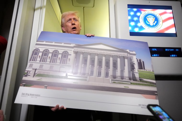 President Donald Trump holds a rendering of the proposed new East Wing of the White House as he speaks to reporters aboard Air Force One en route Sunday from Florida to Washington.