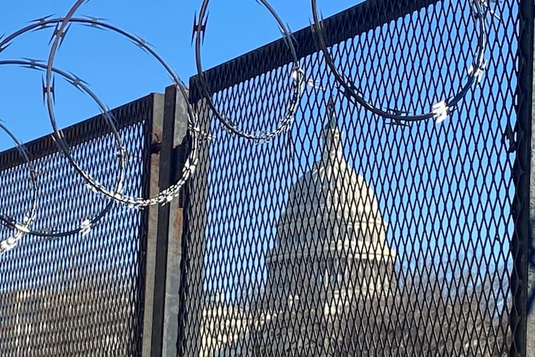 In this Saturday, Jan. 23, 2021 photo, riot fencing and razor wire reinforce the security zone on Capitol Hill in Washington.