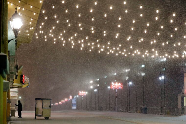 A stands near his Push cart during a snowstorm early Saturday, Jan. 23, 2016, on the Atlantic City Boardwalk. Most of the state was facing a blizzard warning from Friday evening until Sunday that called for up to 24 inches of snow, with the deepest accumulations in the central part of the state.