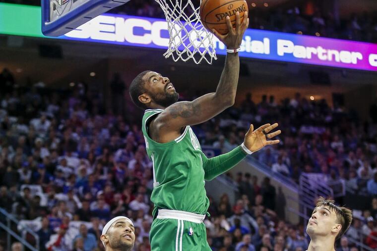 Celtics guard Kyrie Irving lays up the ball past Sixers guard Jerryd Bayless (left) and forward Dario Saric during the teams’ first meeting this season.