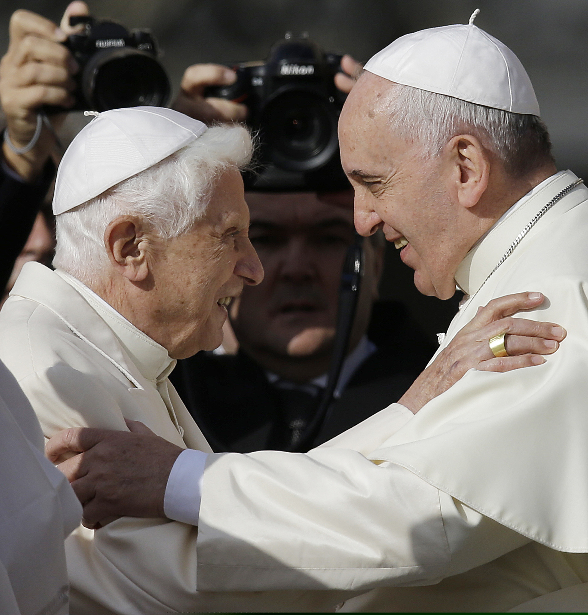 In this September 2014 photo, Pope Francis (right) hugs Pope Benedict XVI prior to the start of a meeting with elderly faithful in St. Peter's Square at the Vatican. Retired Pope Benedict XVI has broken his silence to reaffirm the value of priestly celibacy, co-authoring a bombshell book at the precise moment that Pope Francis is weighing whether to allow married men to be ordained to address the Catholic priest shortage.
