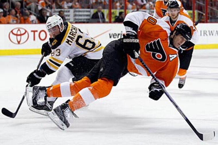 Flyers defenseman Chris Pronger gets tripped by the Bruins' Brad Marchand during the third period. (Yong Kim/Staff Photographer)