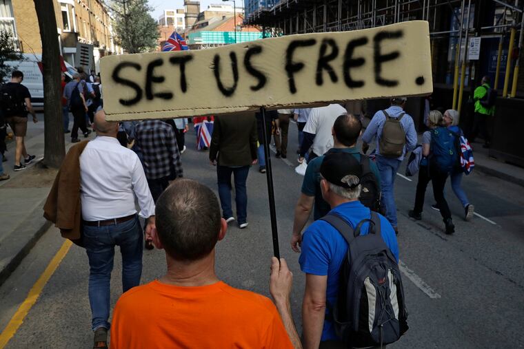 A Pro-Brexit leave the European Union supporter holds a banner as he takes part in the final leg of the "March to Leave" in London, Friday, March 29, 2019. The protest march which started on March 16 in Sunderland, north east England, finishes on Friday March 29 in Parliament Square, London, on what was the original date for Brexit to happen before the recent extension.