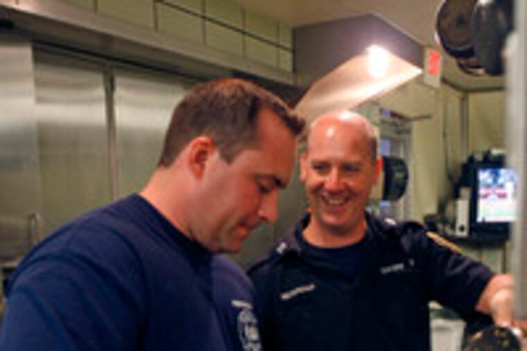 John Sawka sees to the stuffing as Capt. Dennis Merrigan joshes with him at Engine 20. The menu that night included grilled pork chops and glazed carrots.