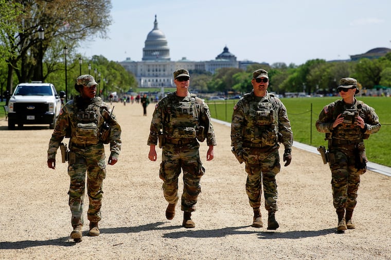 National Guard members patrol the Washington Mall, with the U.S. Capitol in the background, on April 7 in Washington.