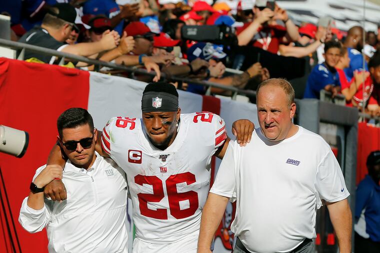 New York Giants running back Saquon Barkley (26) gets helped off the field after getting hurt against the Tampa Bay Buccaneers during the first half of an NFL football game Sunday, Sept. 22, 2019, in Tampa, Fla. (AP Photo/Mark LoMoglio)