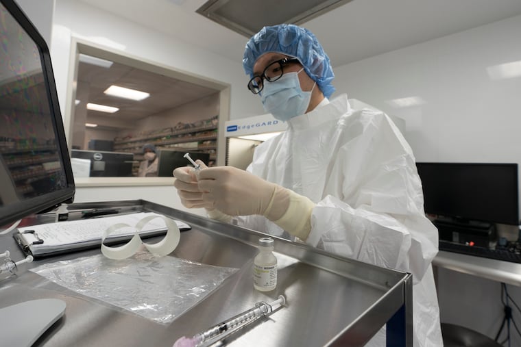 A pharmacist labels syringes in a clean room where doses of COVID-19 vaccines will be handled at Mount Sinai Queens hospital in New York.
