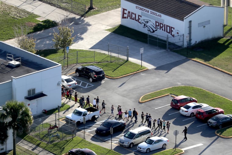 FILE - In this Feb. 14, 2018 file photo. students are evacuated by police from Marjory Stoneman Douglas High School in Parkland, Fla. In more than 600 pages of interviews with investigators, released Dec. 19, officers each gave their individual tale of how a peaceful Valentine’s Day suddenly turned to horror when they learned of the shooting at the high school. (Mike Stocker/South Florida Sun-Sentinel via AP)