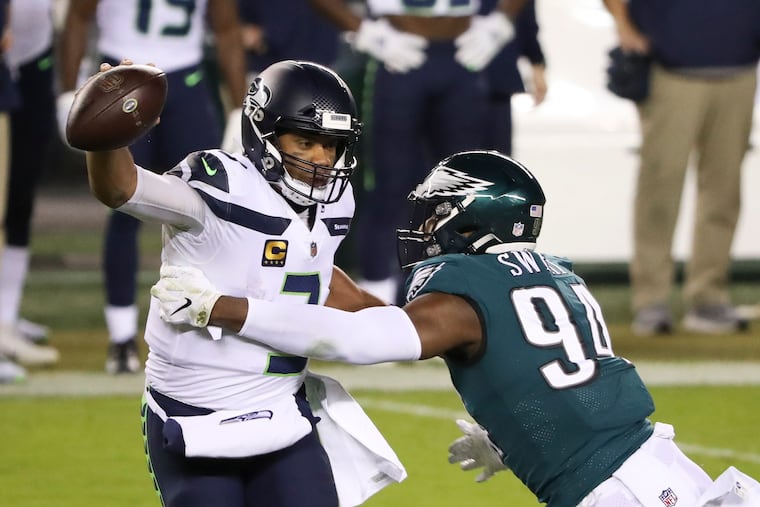 Seattle Seahawks quarterback Russell Wilson moves past Eagles defensive end Josh Sweat during the second quarter on Monday, November 30, 2020.