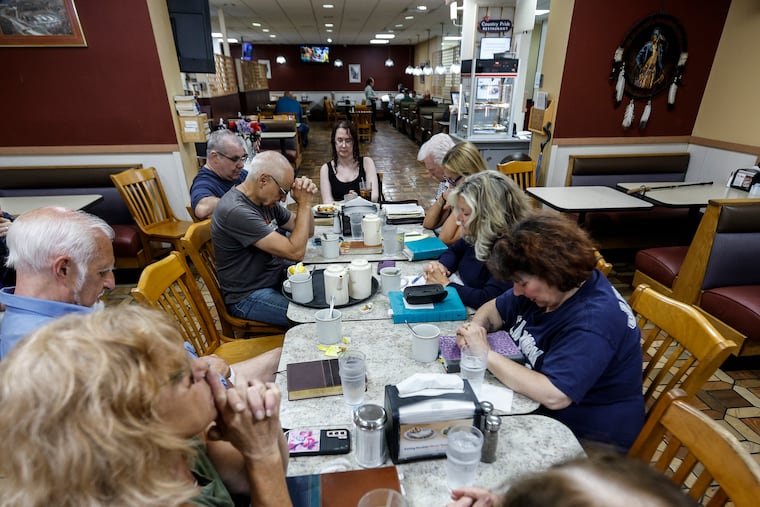 Starting the gathering with a prayer, Sherry Blackman (center right), a pastor at Church of the Mountain in the Delaware Water Gap, sees worshippers weekly at a Columbia, N.J., truck stop.