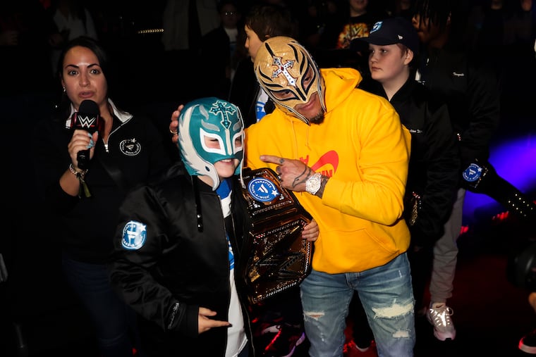 WWE superstar Rey Mysterio poses for a photo with Sean Donahue, 9, with Make-A-Wish at WWE World at Wrestlemania inside the Convention Center on Thursday.