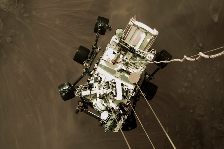NASA shows the Perseverance rover lowered towards the surface of Mars during its powered descent on Thursday. (via AP)